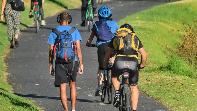 people cycling and walking to work. Commuting along the yarra.